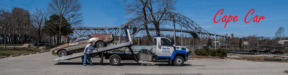 Cape Car tow truck hauling a junk car
